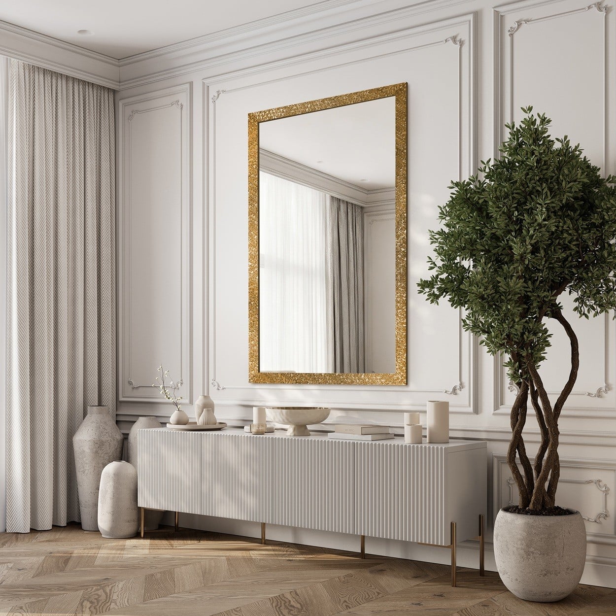 Elegancki salon z białą zabudową, dużym lustrem w złotej ramie nad konsolą i topiarią w doniczce
